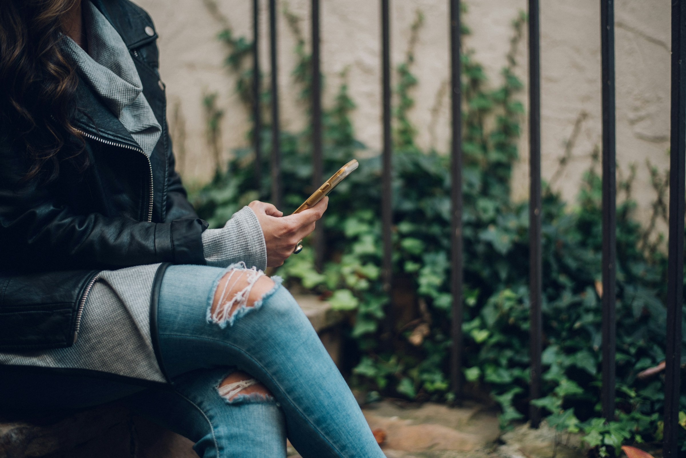 woman sitting and using her phone